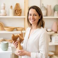 Évi Hajema, inkoper van 1A Decor de Wit, met houten decoratie in een lichte showroom